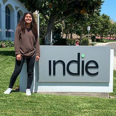 Photo of a woman standing next to an indie Semiconductor sign.